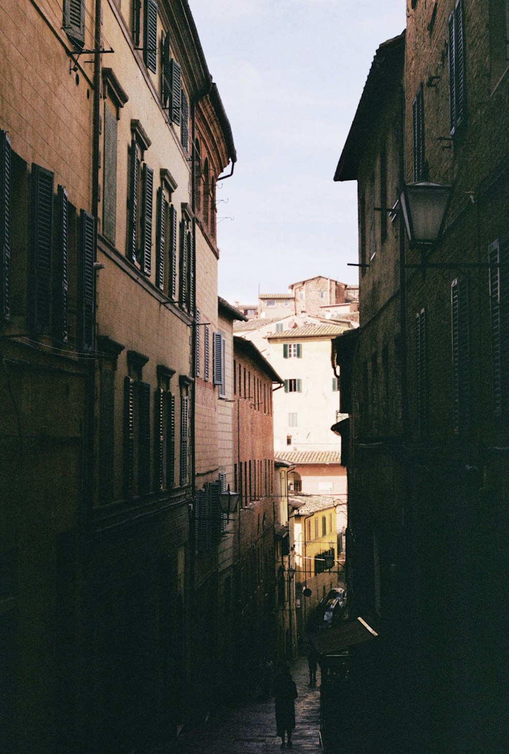 a person walking down a narrow alley way