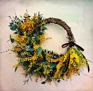 a wreath with yellow flowers hanging on a wall