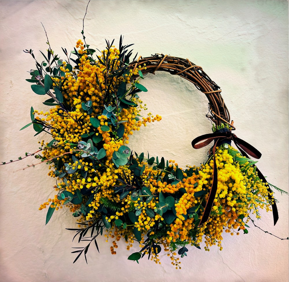 a wreath with yellow flowers hanging on a wall