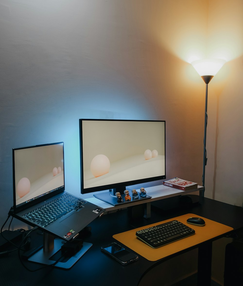 uma mesa com dois monitores e um laptop