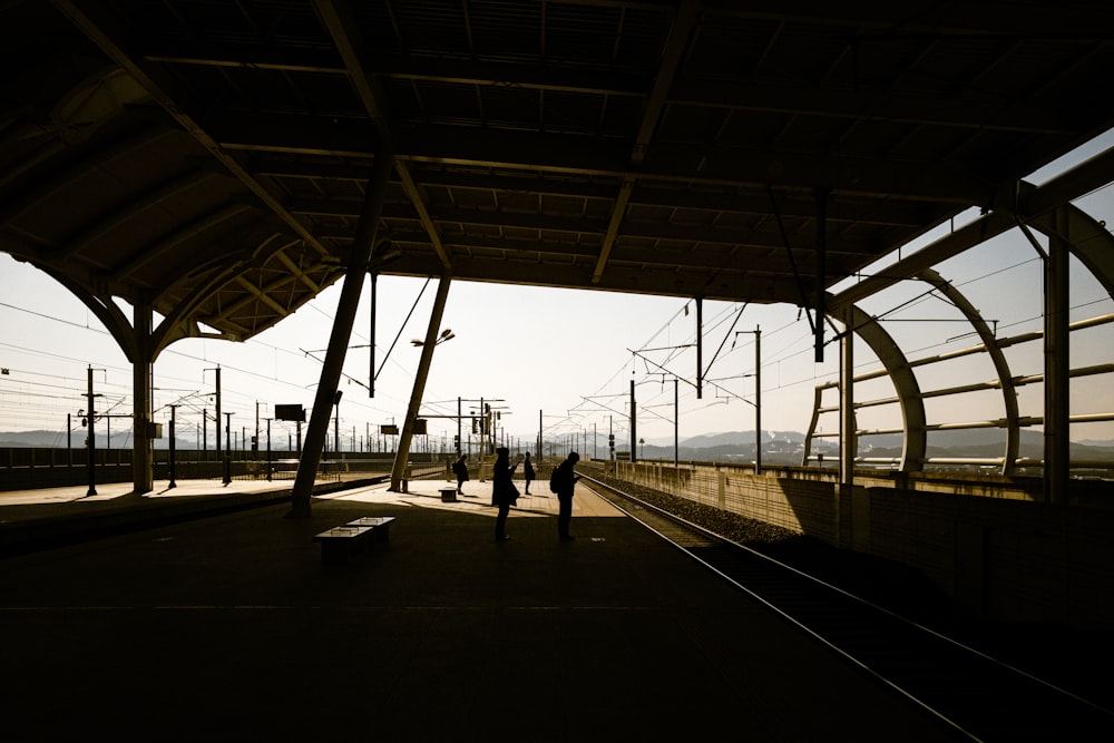 um casal de pessoas em pé em uma estação de trem