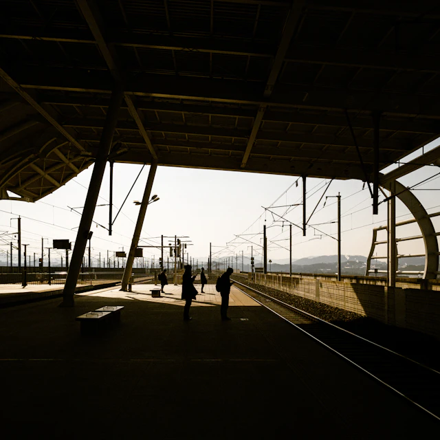Two people standing on a train station platform in Korea, a street photograph