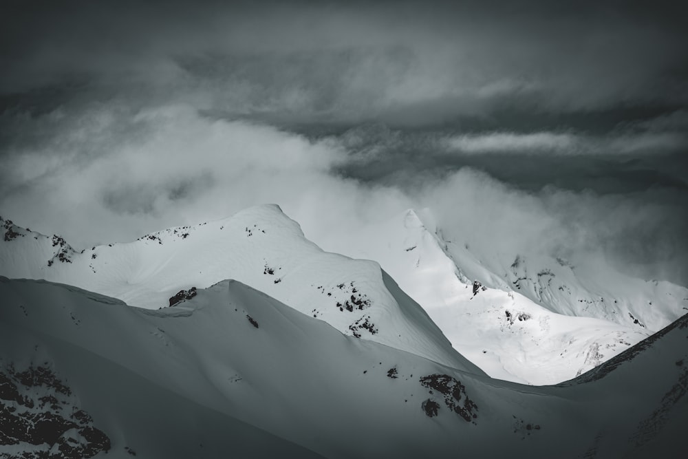 a mountain covered in snow under a cloudy sky