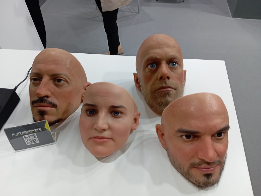 a group of people with bald heads on display