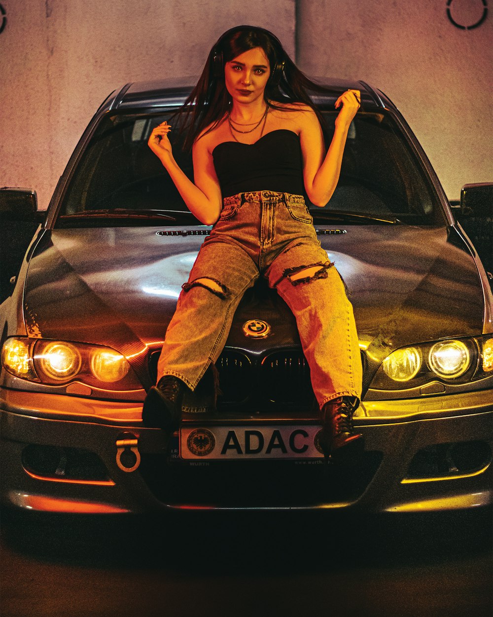 a woman sitting on the hood of a car