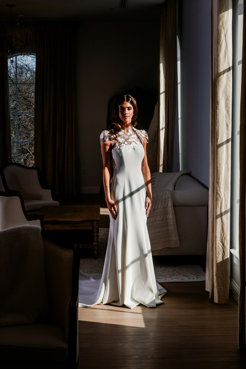 a woman in a white dress standing in a room