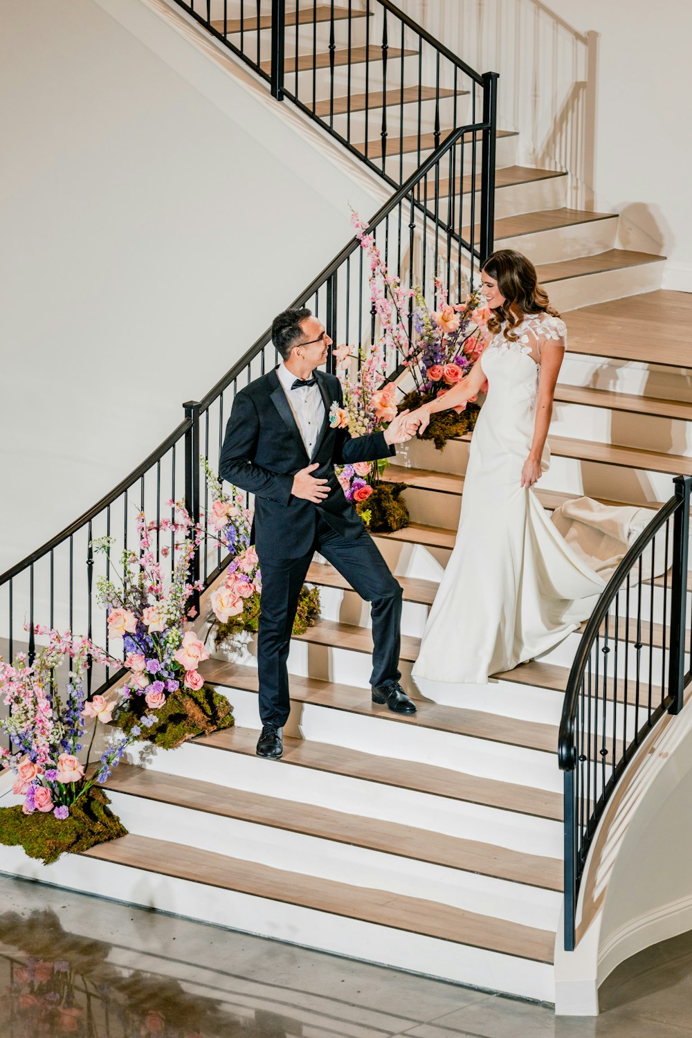 a bride and groom walking down the stairs