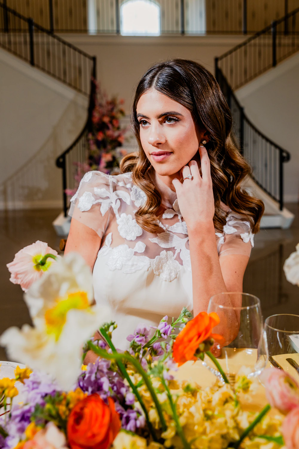 Novia sentada a la mesa rodeada de amapolas y flores de colores