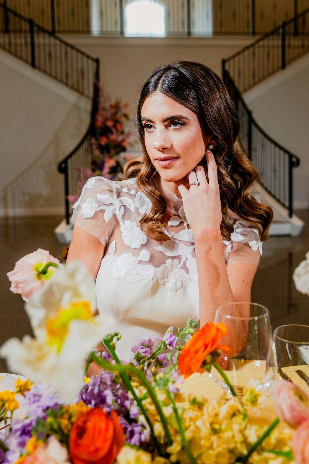 a woman sitting at a table with flowers in front of her