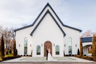 a bride and groom standing in front of a church