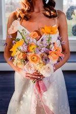 a woman in a wedding dress holding a bouquet of flowers