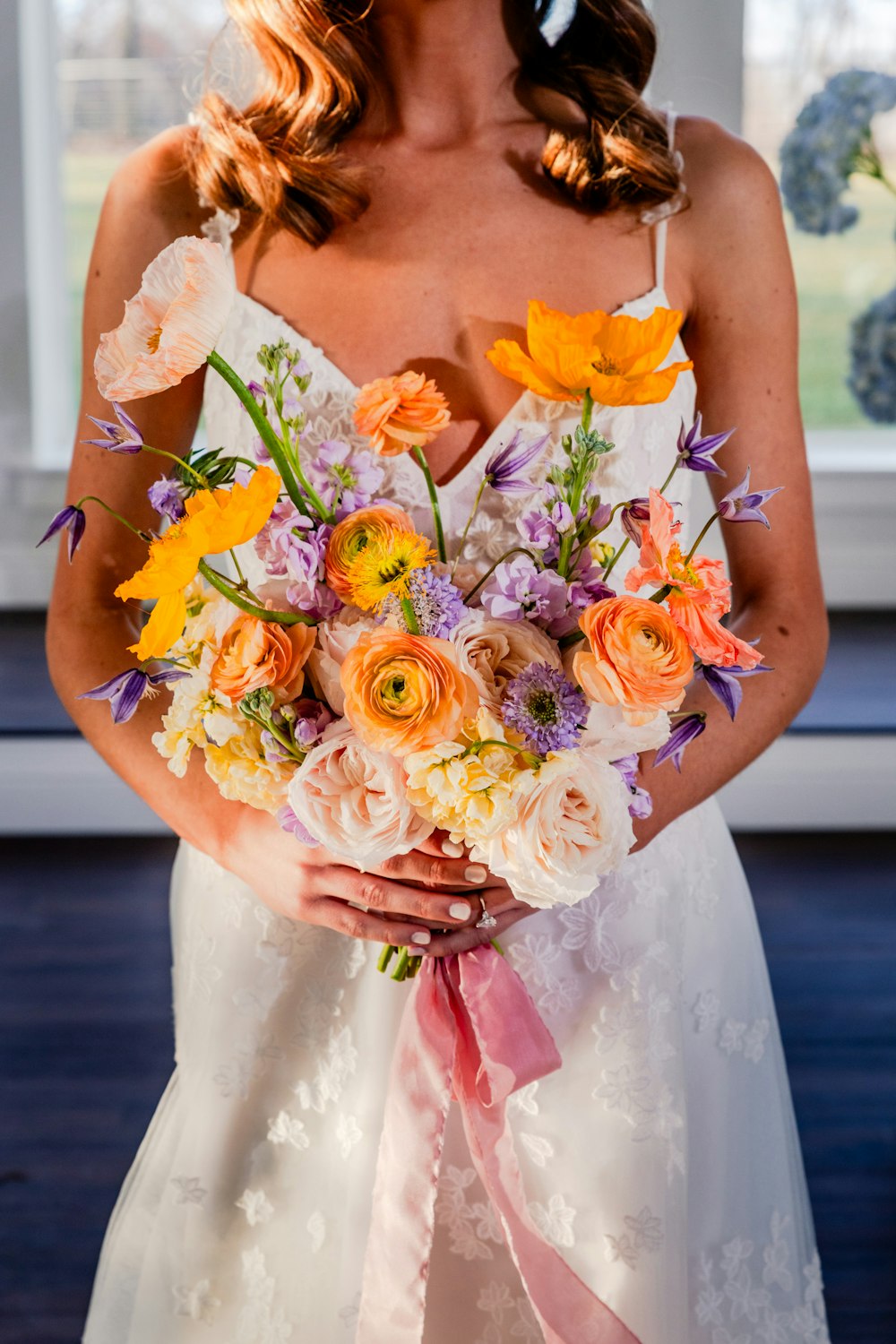 una donna in un abito da sposa che tiene un mazzo di fiori