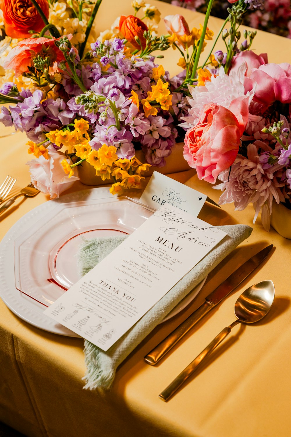 a place setting with flowers and a menu