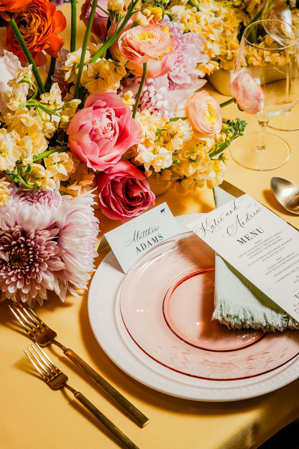 a table set with a place setting and flowers