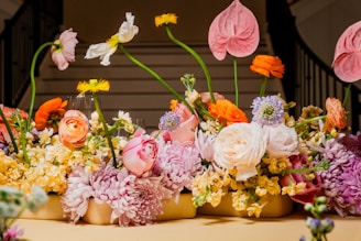 a group of vases filled with different colored flowers