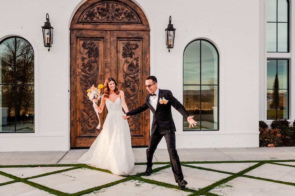 a bride and groom standing in front of a building