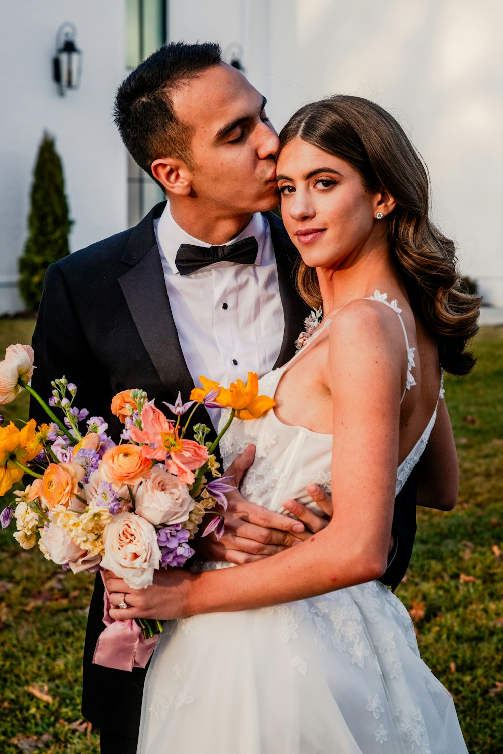 a bride and groom kissing in front of a church