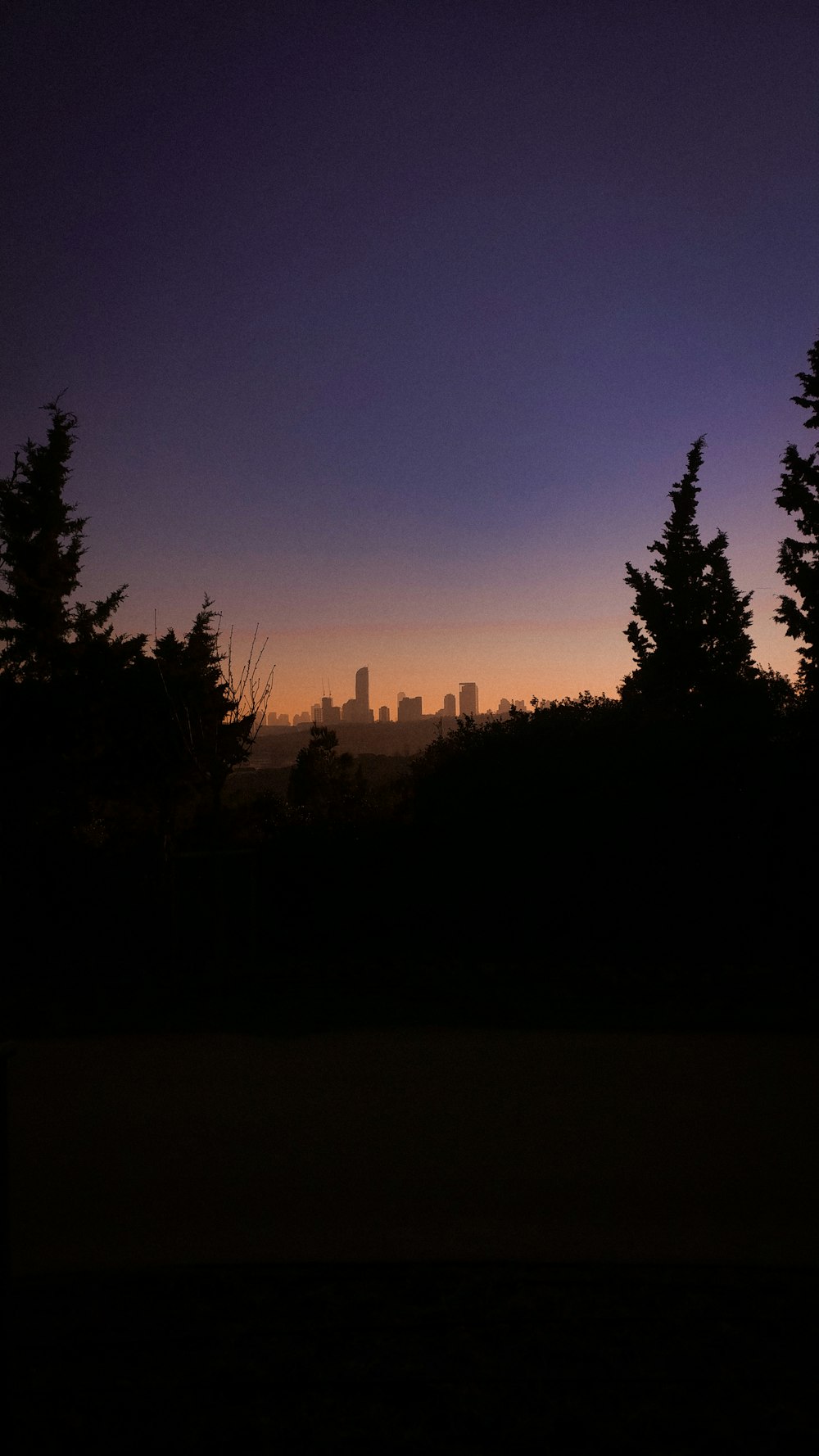 a view of a city from a hill at sunset