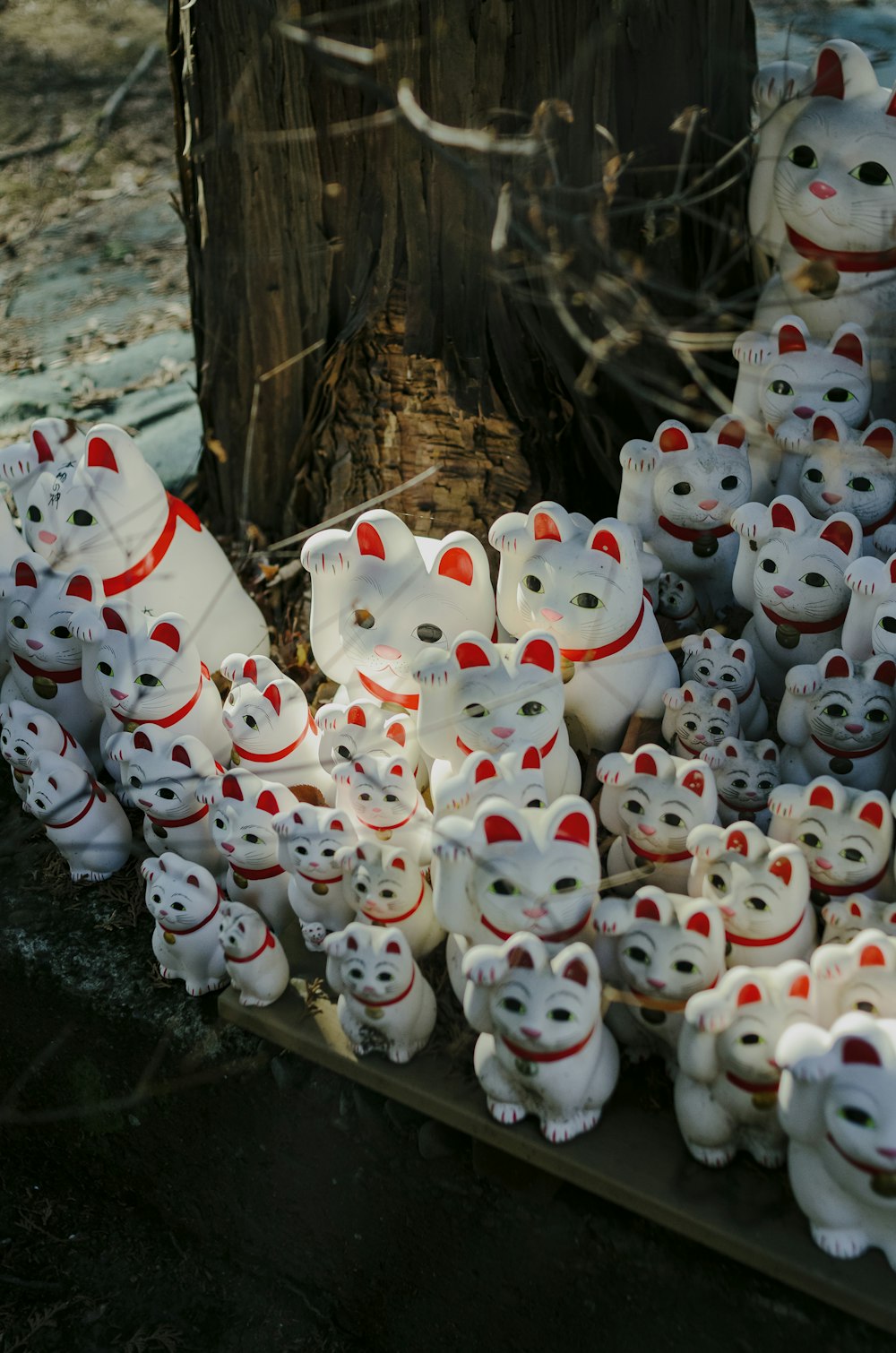 a bunch of white teddy bears sitting next to a tree