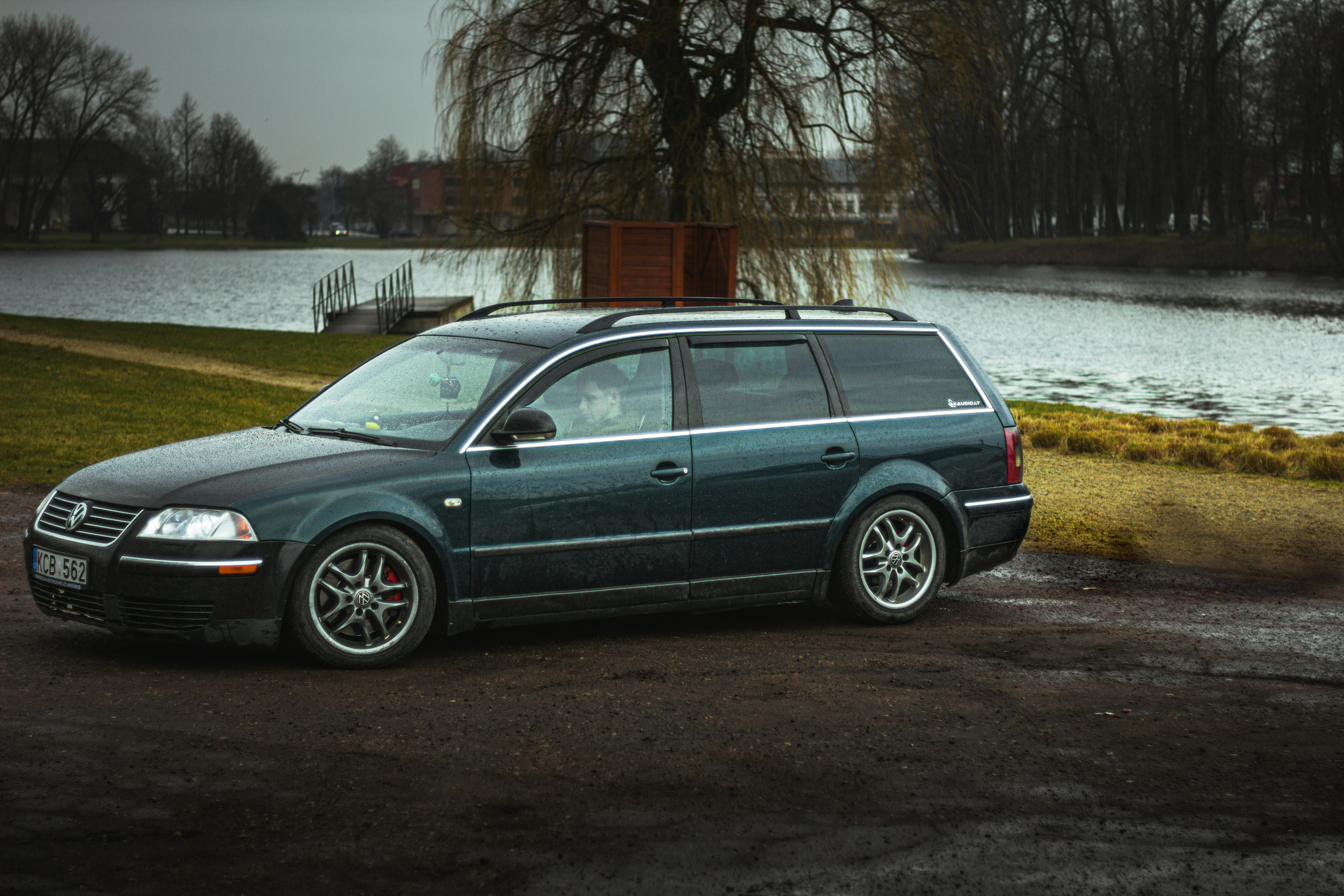 a car parked in a parking lot next to a lake
