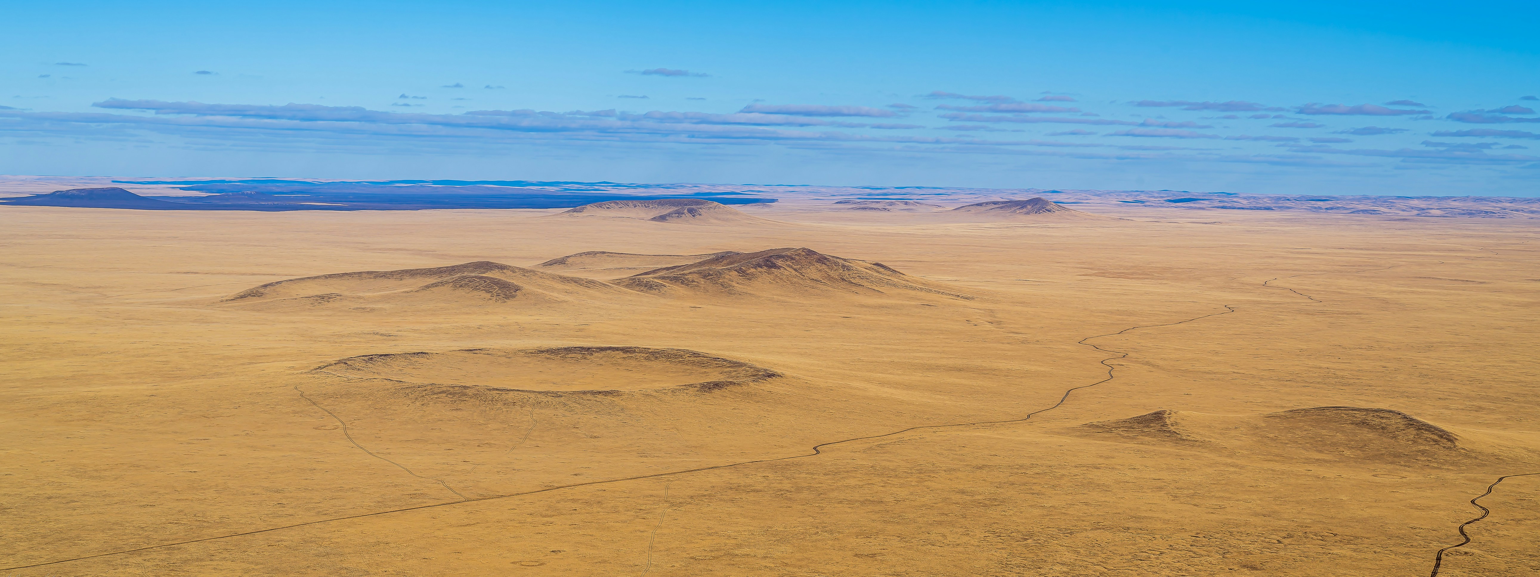 an aerial view of a desert with mountains in the distance