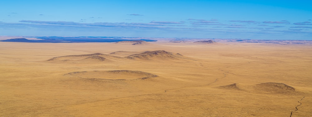 an aerial view of a desert with mountains in the distance