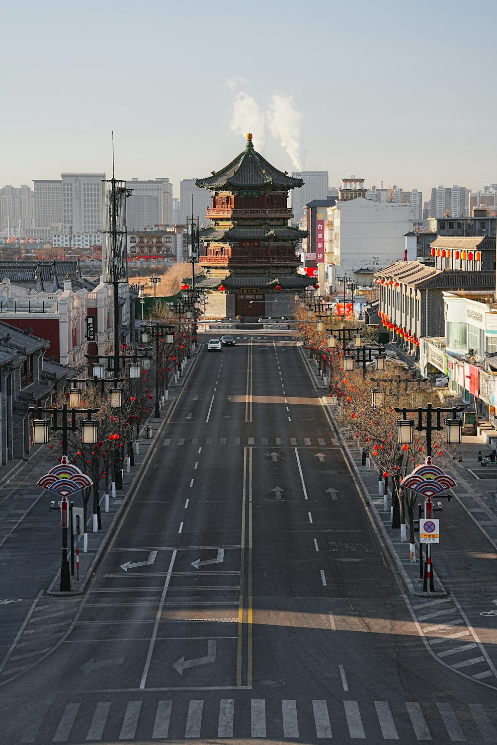 an empty street with a tall building in the background