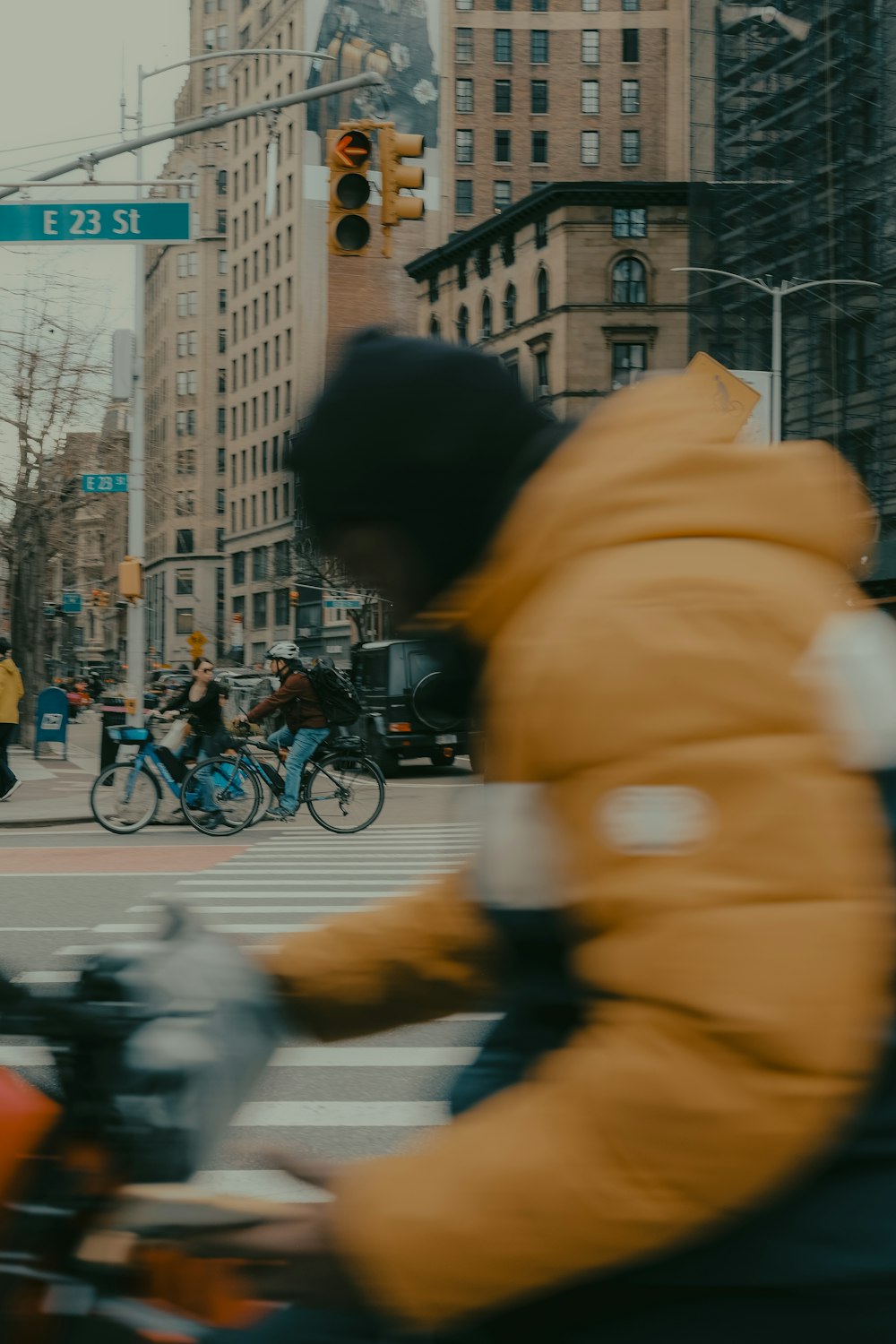 a man riding a motorcycle down a street next to tall buildings