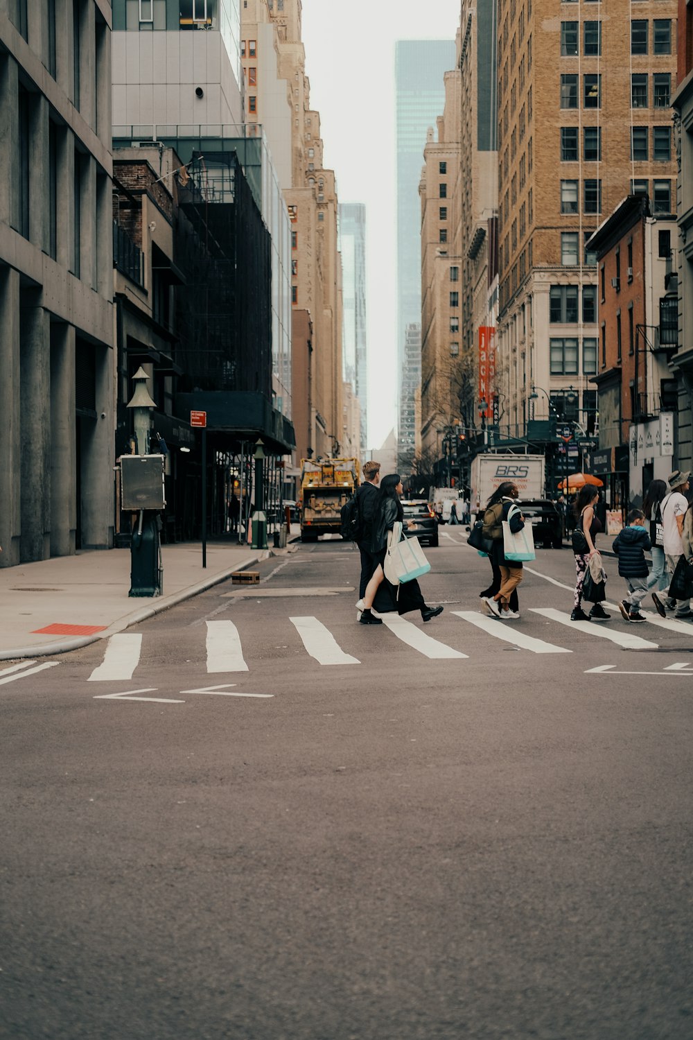 a group of people crossing a street in a city