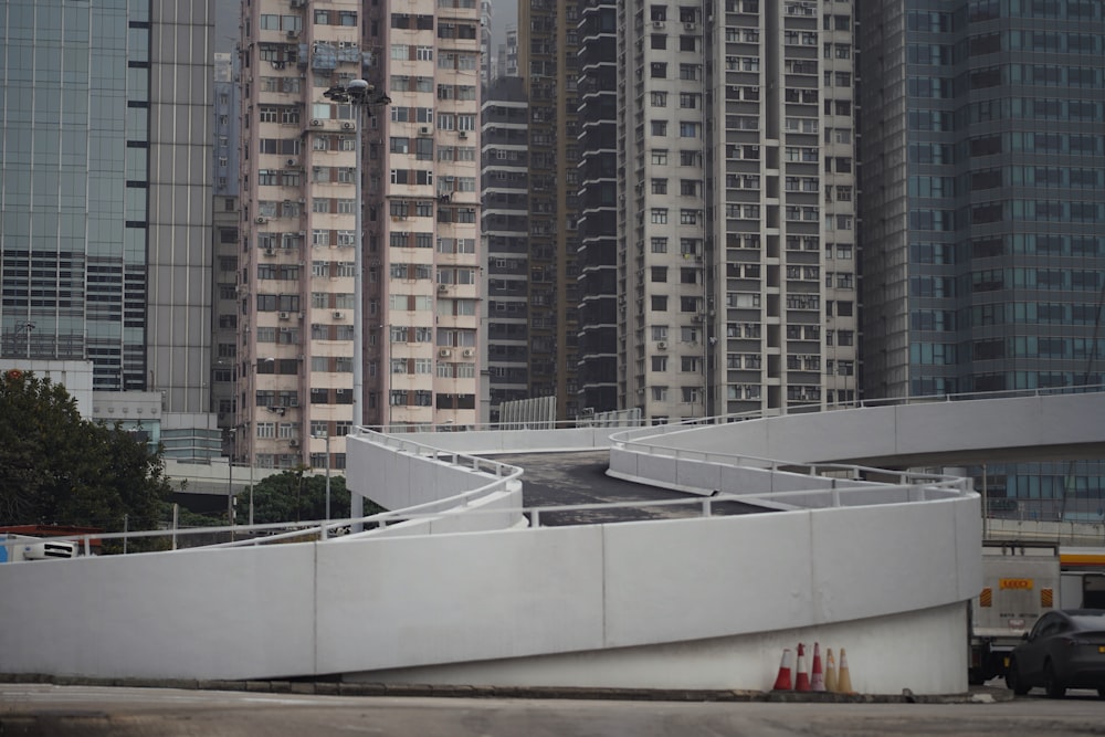 a white building with a curved roof in the middle of a city