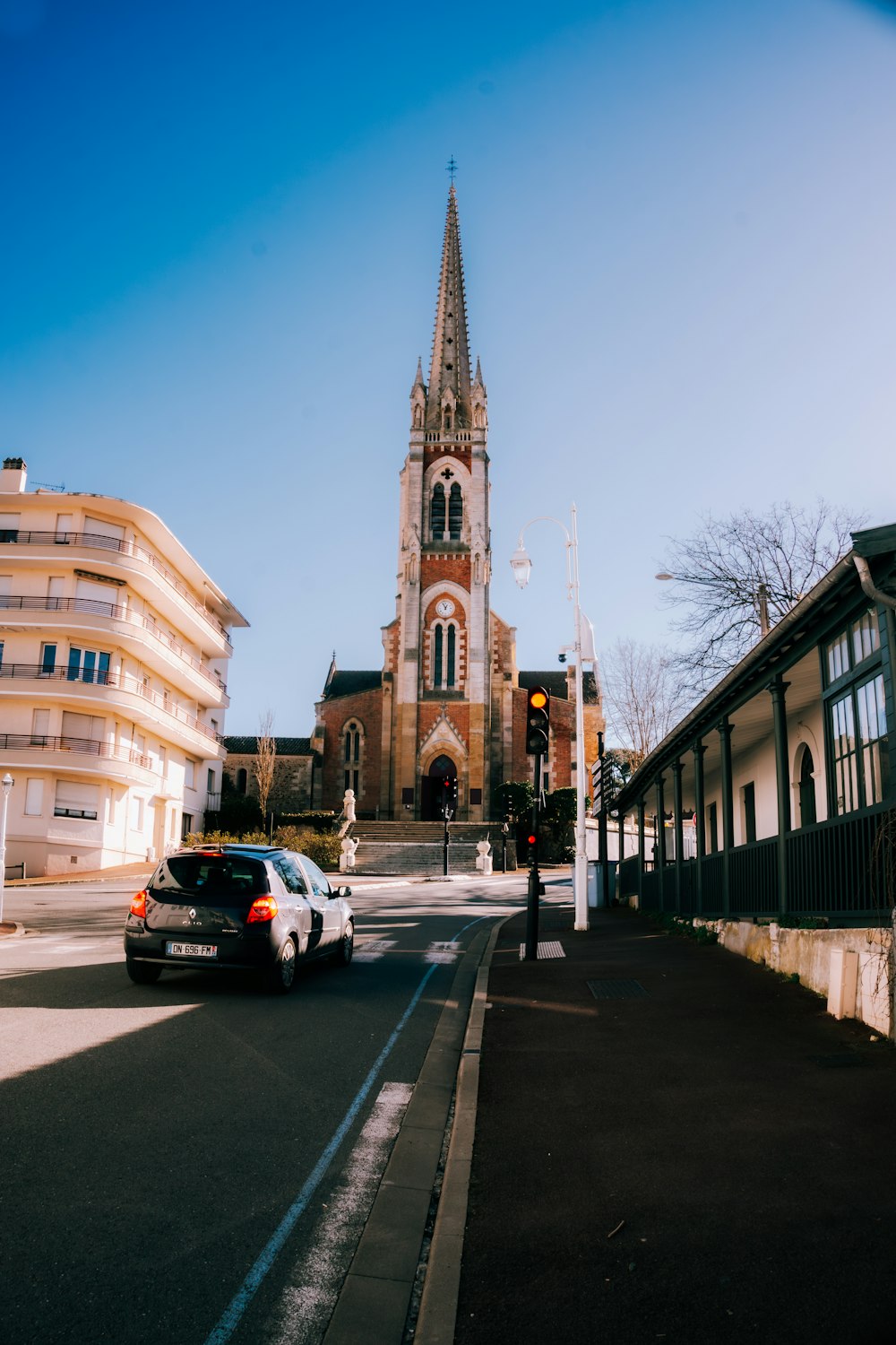 a car driving down a street next to a tall church
