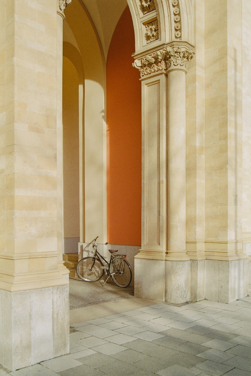 Un vélo est garé sous l’arche d’un bâtiment