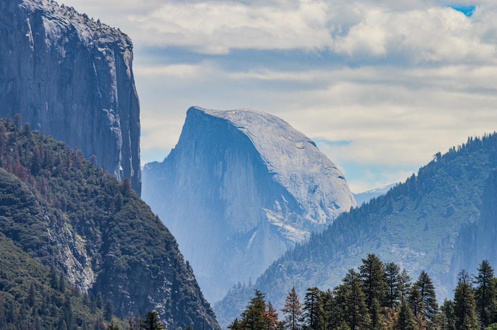 a view of a mountain range with trees in the foreground