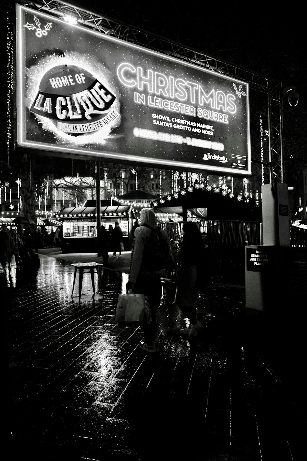 una foto in bianco e nero di persone che camminano sotto la pioggia