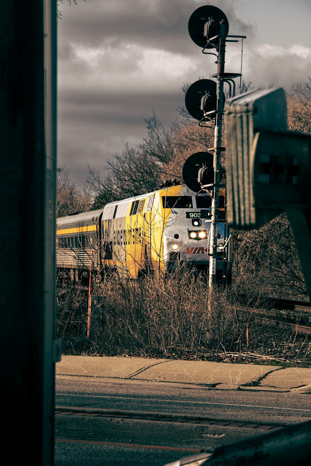 a train traveling through a rural countryside under a cloudy sky