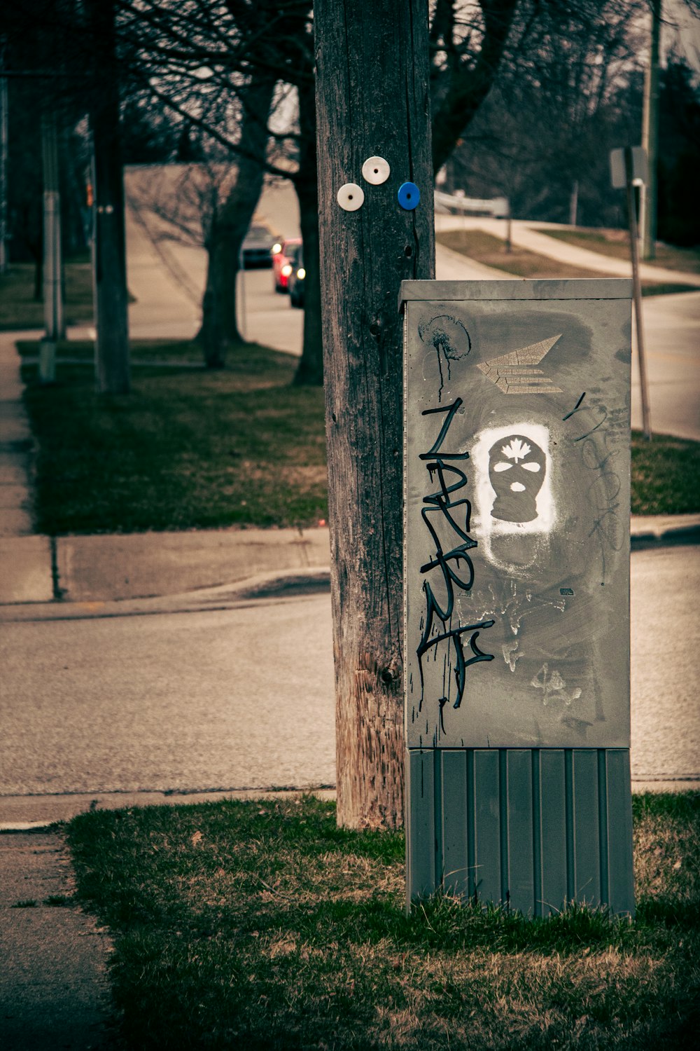 a pole with graffiti on it next to a street