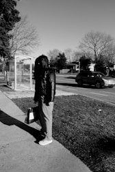 a man standing on a sidewalk next to a bus stop