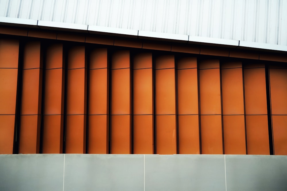 an orange building with a white roof and a metal wall