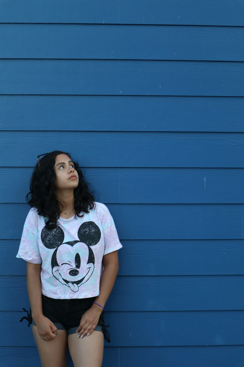 a woman standing in front of a blue wall