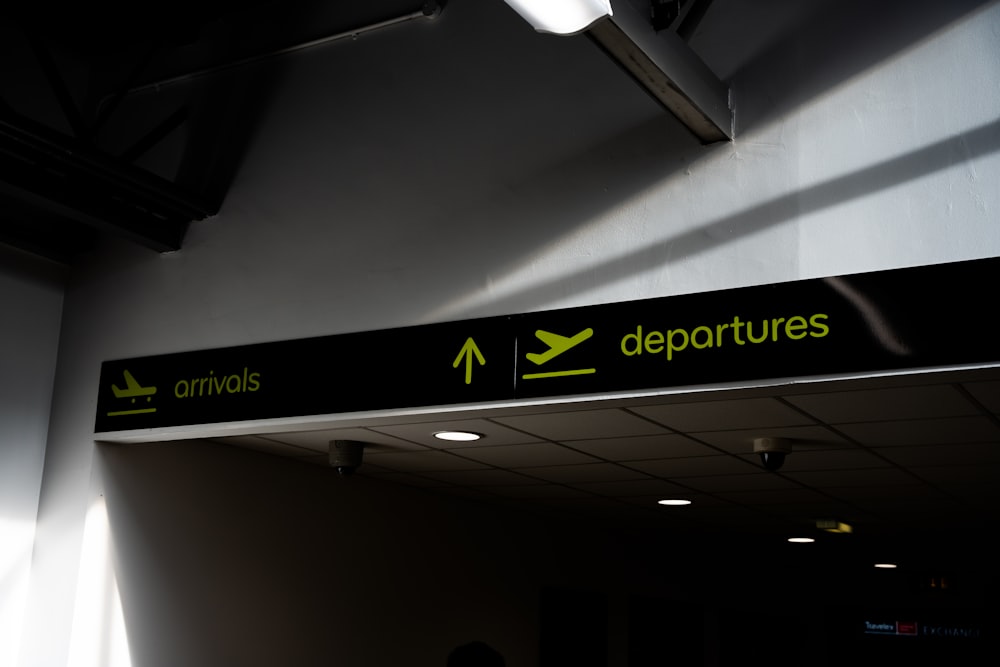 a black and green sign hanging from the side of a wall