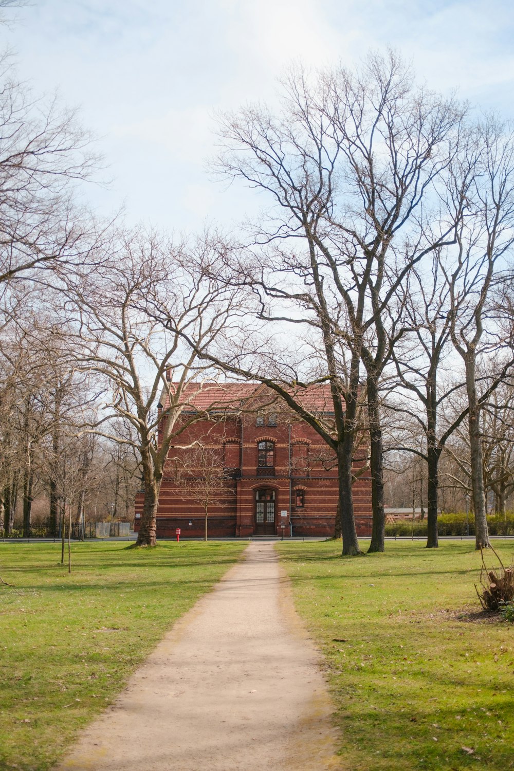 a path leading to a brick building in a park