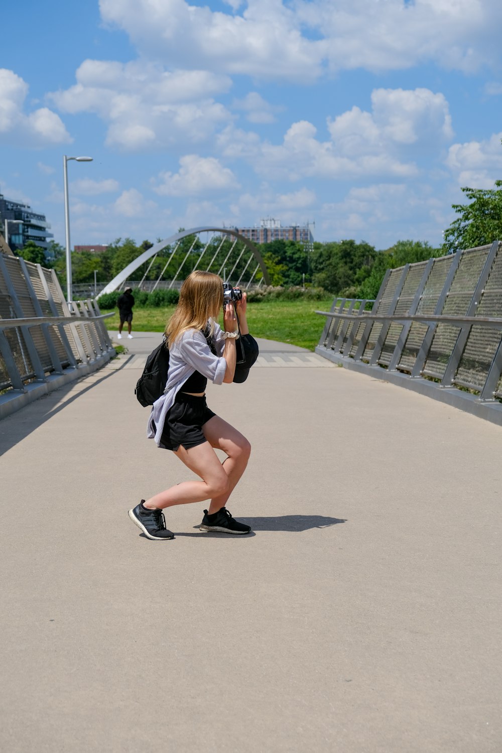 a woman taking a picture of herself on a bridge