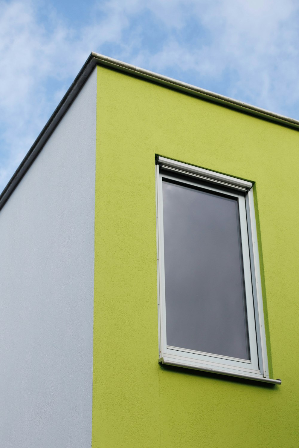 a green and white building with a window