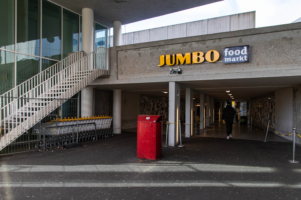 a jumbo food market with a red trash can