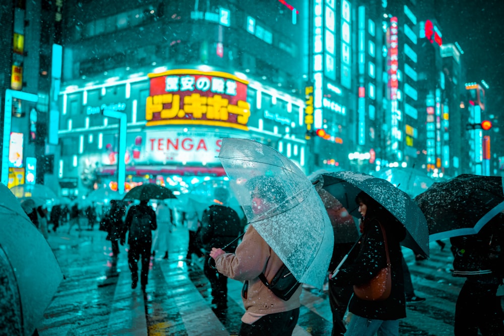 a group of people walking down a street holding umbrellas
