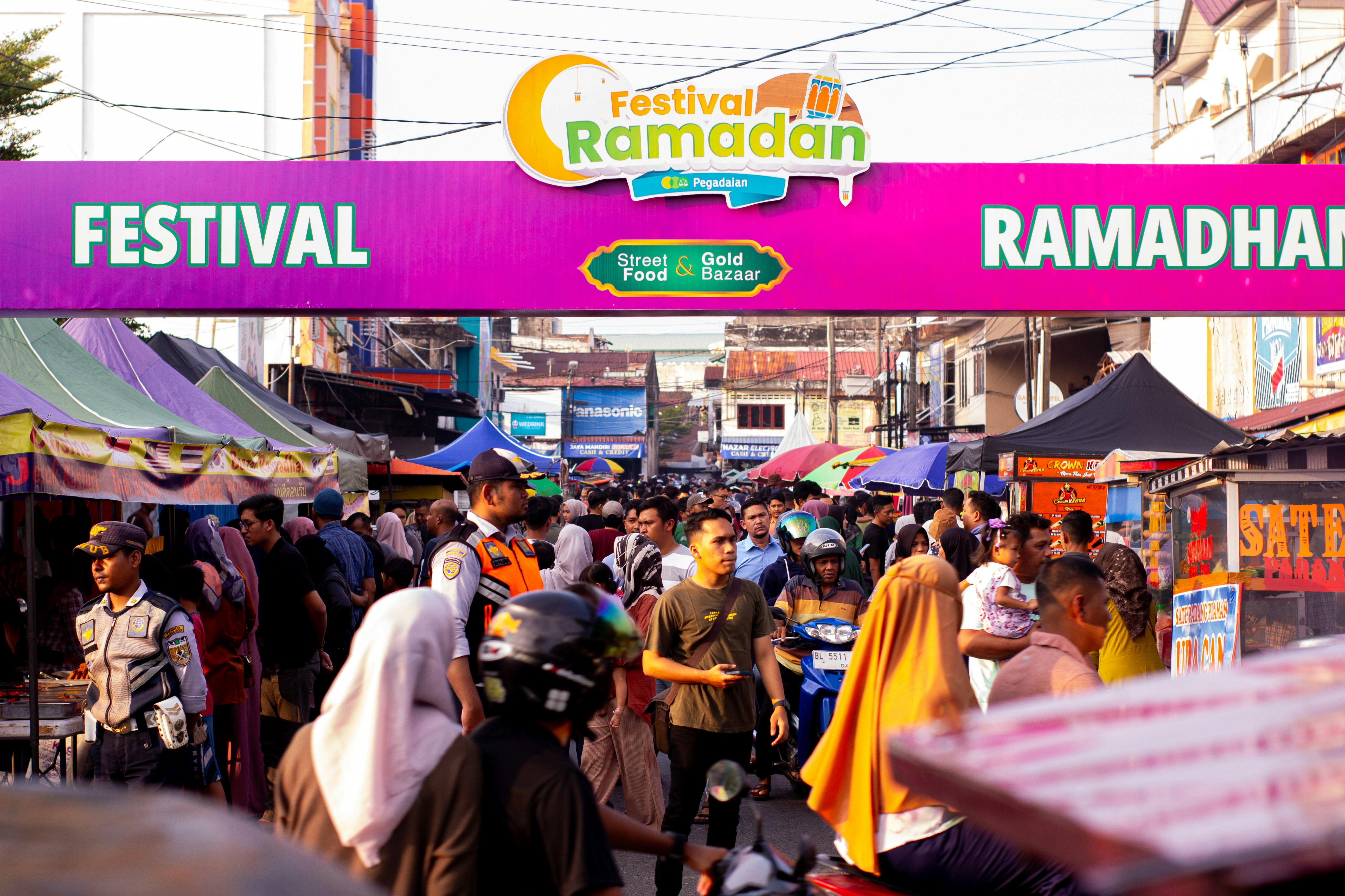 Crowded evening scene at Mehran Walk with families enjoying food and live music during Ramadan festival