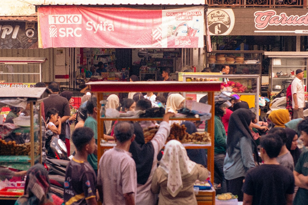 uma multidão de pessoas em pé ao redor de um mercado