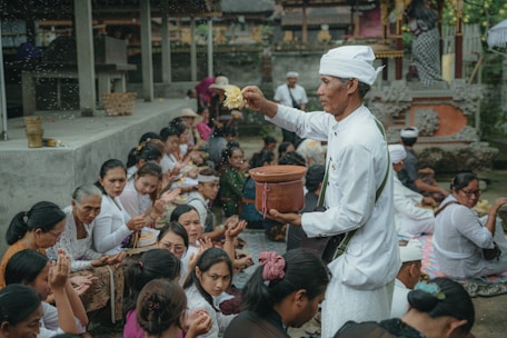 a group of people sitting around a man in a chef's hat