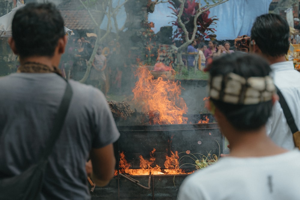 a group of people standing around a fire pit