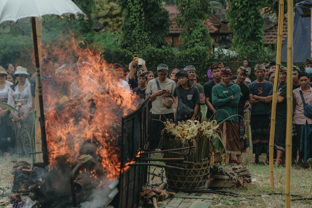 a group of people standing around a fire pit